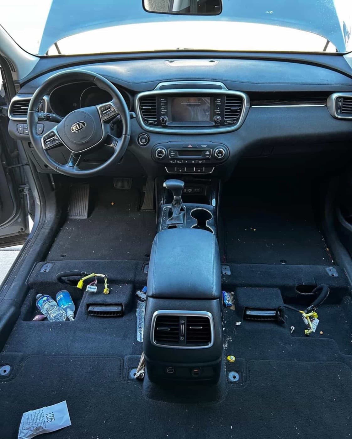 Kia Sorento interior before detailing — trash and debris on floor