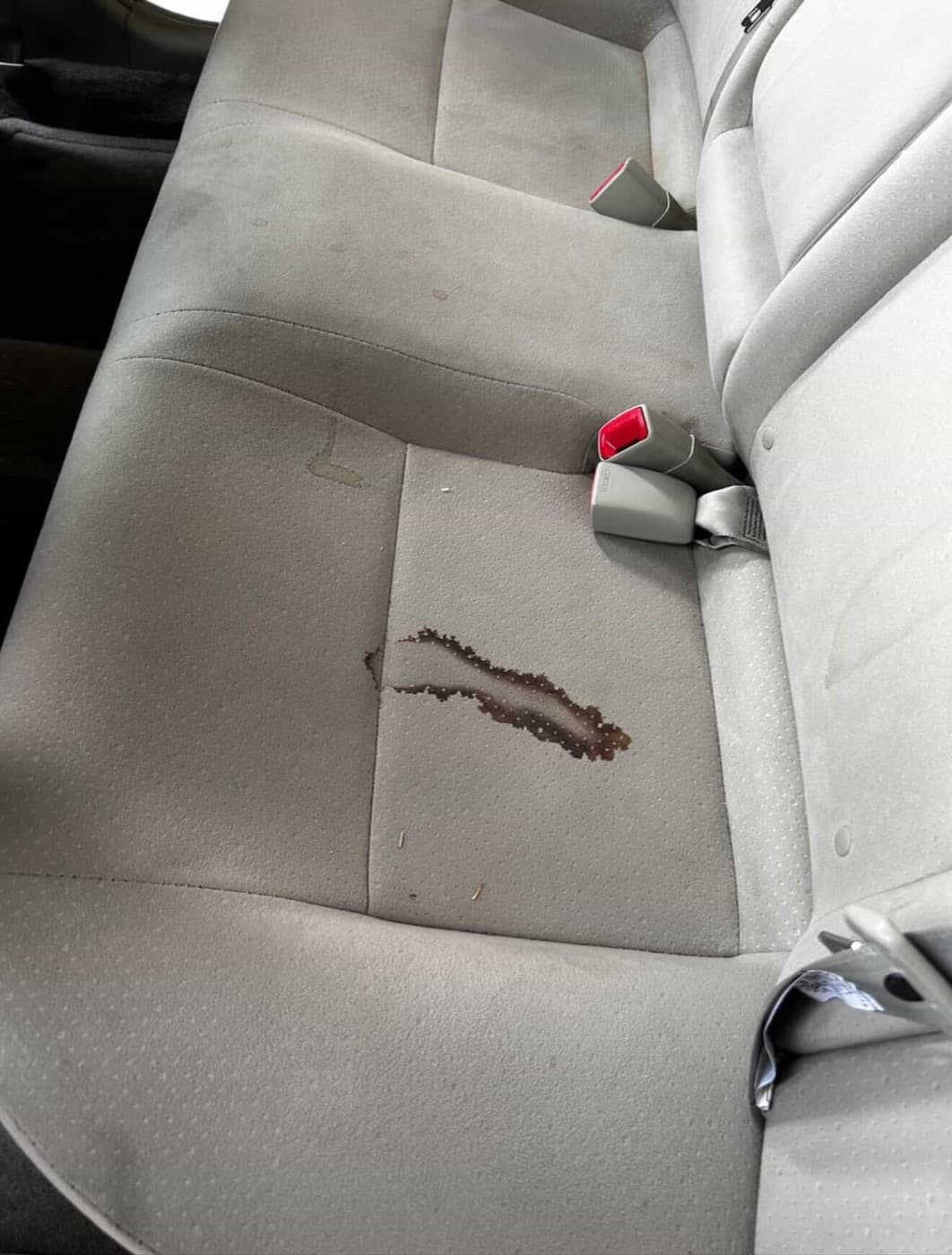 Car rear seat before detailing — stained fabric